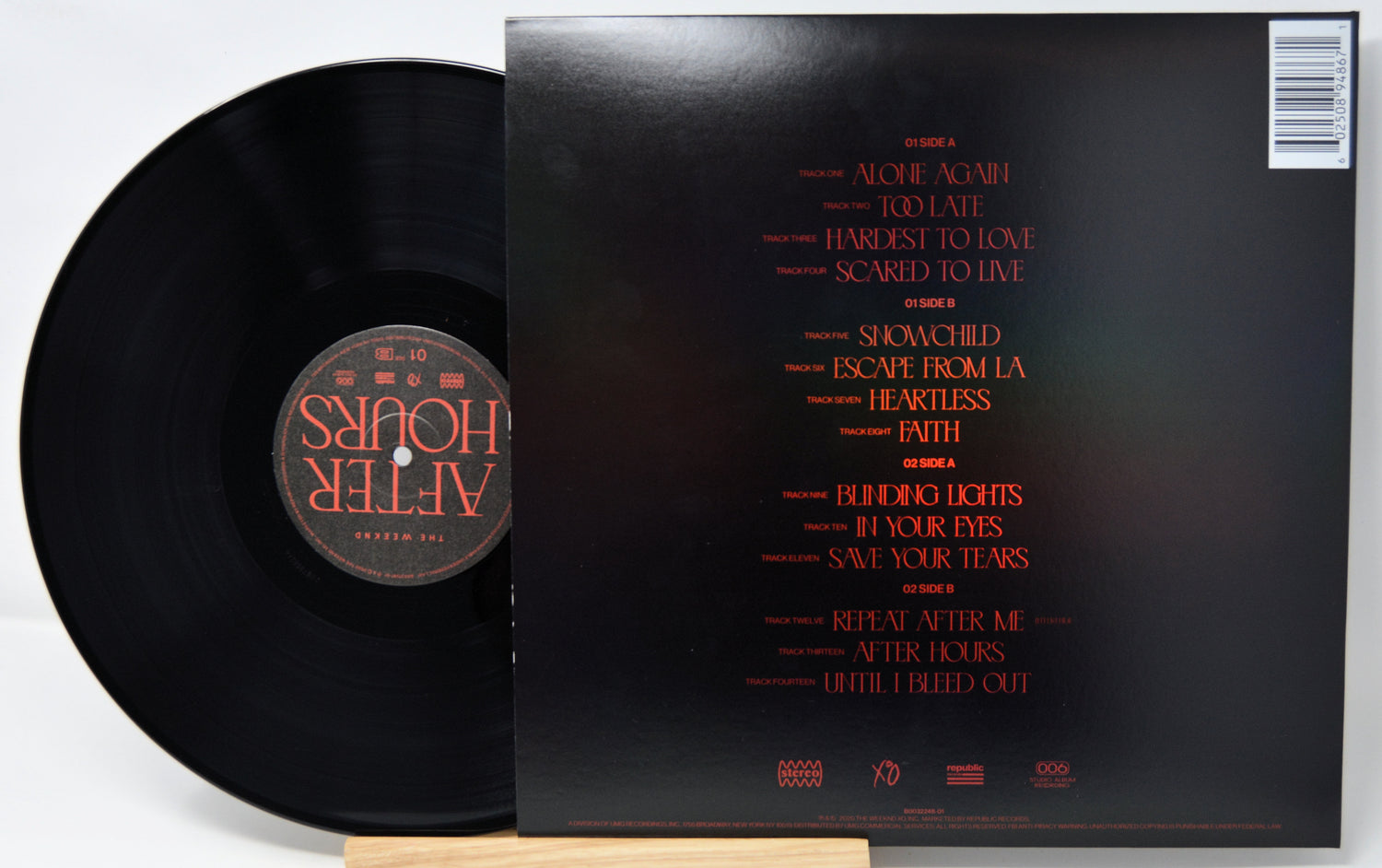 Vinyl record with cover displaying tracklist on a white background