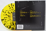 Vinyl record with yellow and black pattern on one side and back cover with text on the other, on a white background.
