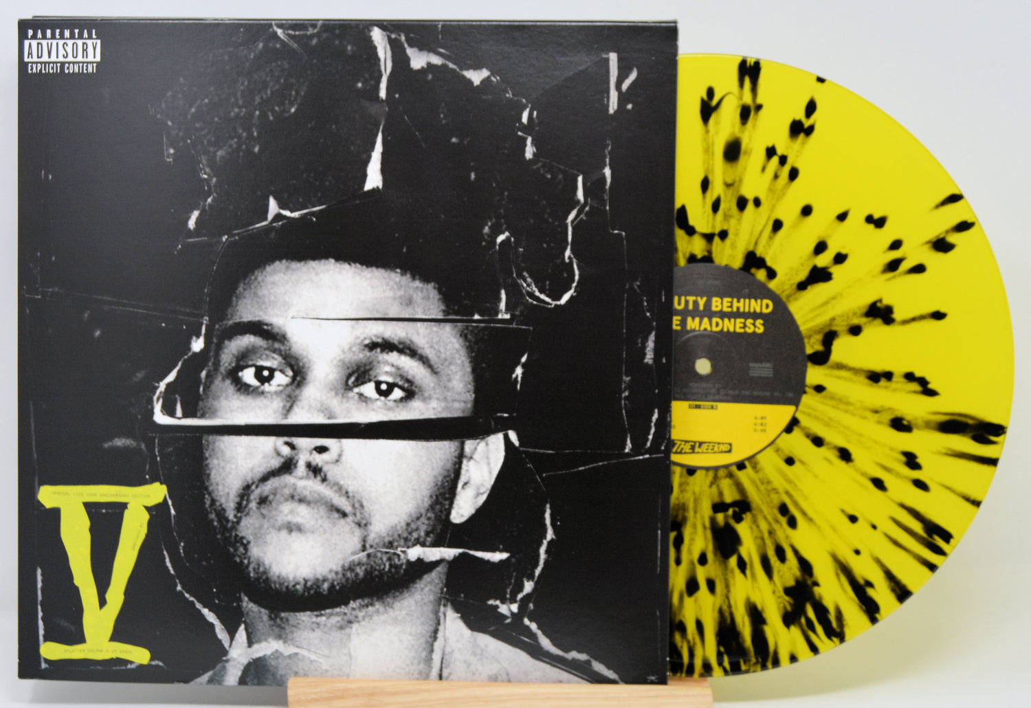 Vinyl record with a black and yellow design and a cover featuring a person's face.