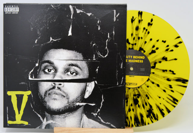 Vinyl record with a black and yellow design and a cover featuring a person's face.