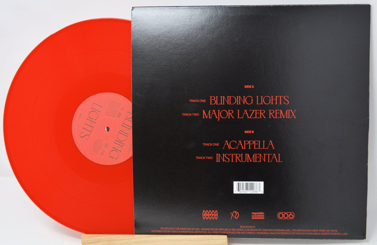 Red vinyl record with black cover displaying text on a white background