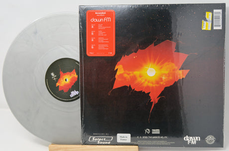 Vinyl record with a red and orange abstract design on the cover, featuring the label 'dawn FM'.