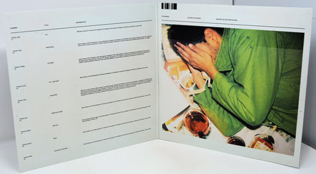 Open book with a photograph of a person in a green shirt on the right page.