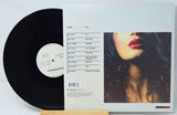 Vinyl record with cover featuring a woman's face on a light gray background