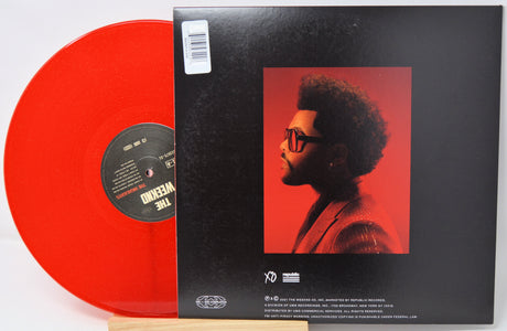 Red vinyl record with a black cover featuring an image of a person on a white background