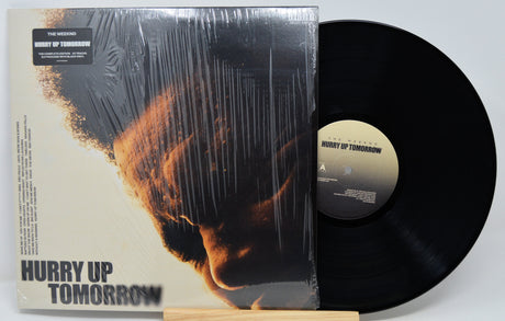 Vinyl record and cover titled 'Hurry Up Tomorrow' by The Weeknd on a white background