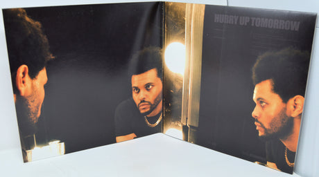 Vinyl record with a cover featuring a person's face and album title 'Hurry Up Tomorrow'.