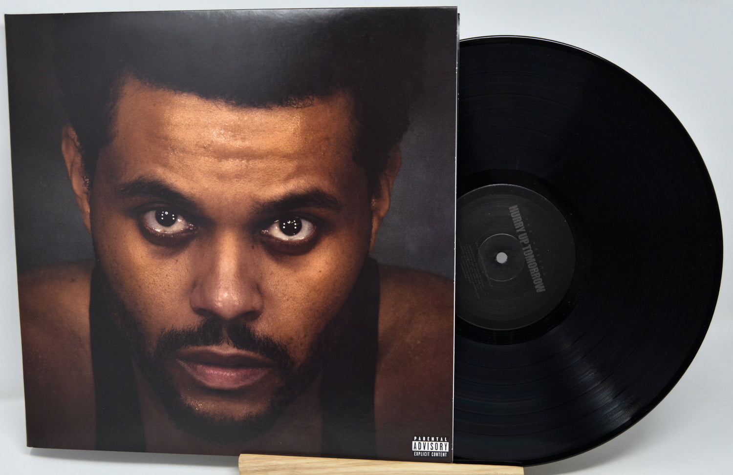 Vinyl record with a cover featuring a close-up of a person's face on a white background