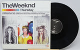Vinyl record with 'The Weeknd' album cover featuring three women and a black record.