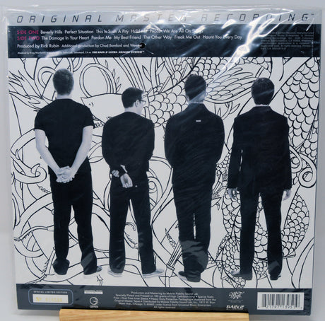 The back cover of the vinyl record 'Original Mystery Reptile' by the band EAGLE, featuring a black and white illustration of four men in suits from behind against a patterned background.