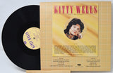 Vinyl record and cover with 'Kitty Wells' on a light gray background