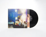 Vinyl record with a colorful cover featuring people in a room.