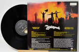 A vinyl record partially pulled from its back cover sleeve, showing the black record on the left and the printed back cover artwork on the right. The sleeve features a fiery orange-and-black concert scene with the Whiteknock logo and track listing text.