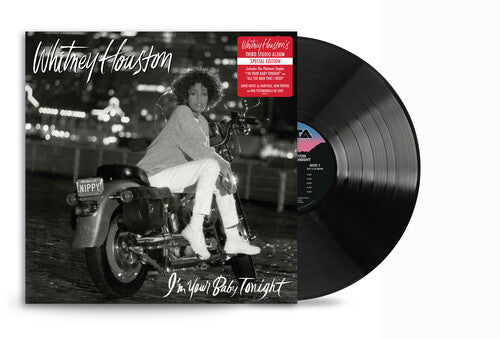 Vinyl record with cover featuring a person on a motorcycle, Whitney Houston album art.