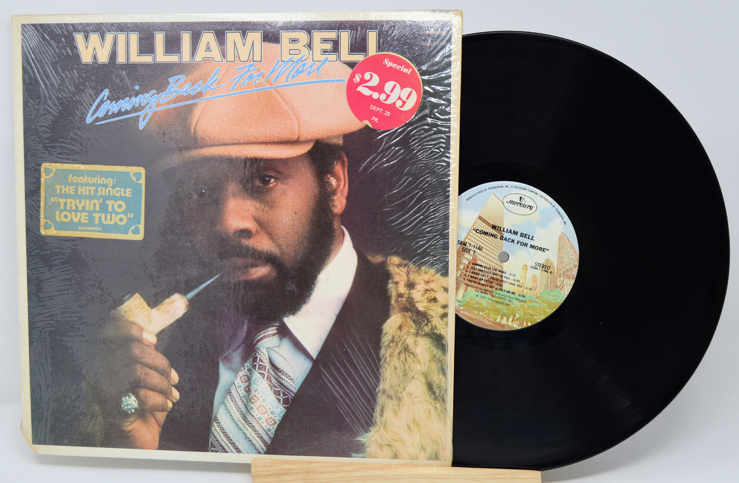 Vinyl record with cover featuring a man and pricing information on a white background