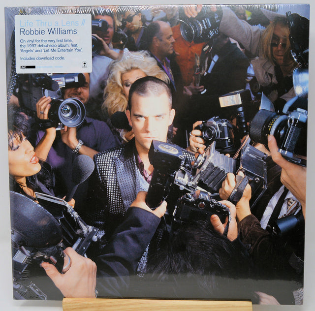 Vinyl record cover with a collage of a man surrounded by photographers and cameras.