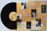 Vinyl record with a detailed album cover featuring black and white images and text.