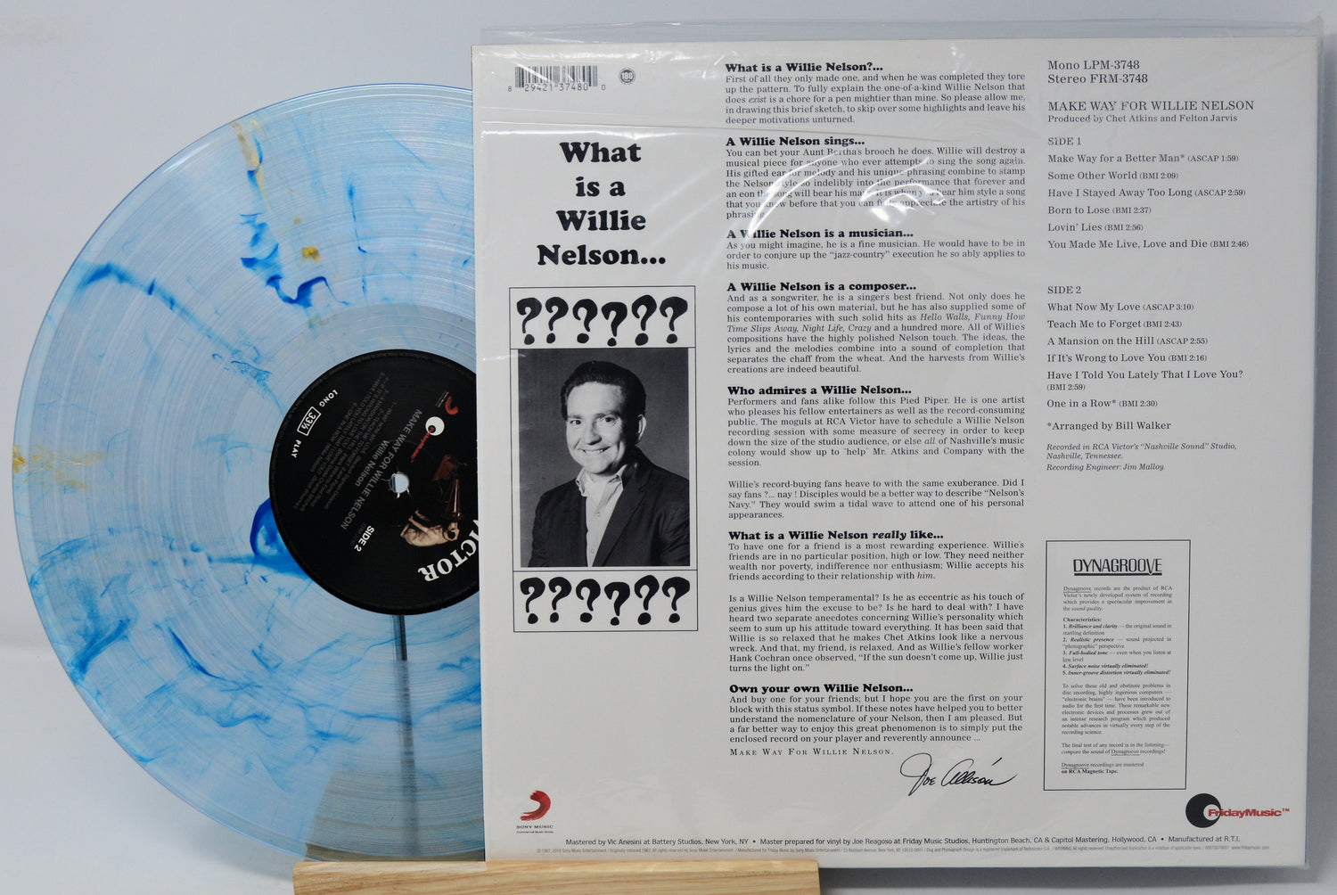 Vinyl record album shown with the back cover and a translucent marbled blue-and-white record partially visible behind it, photographed on a white background.