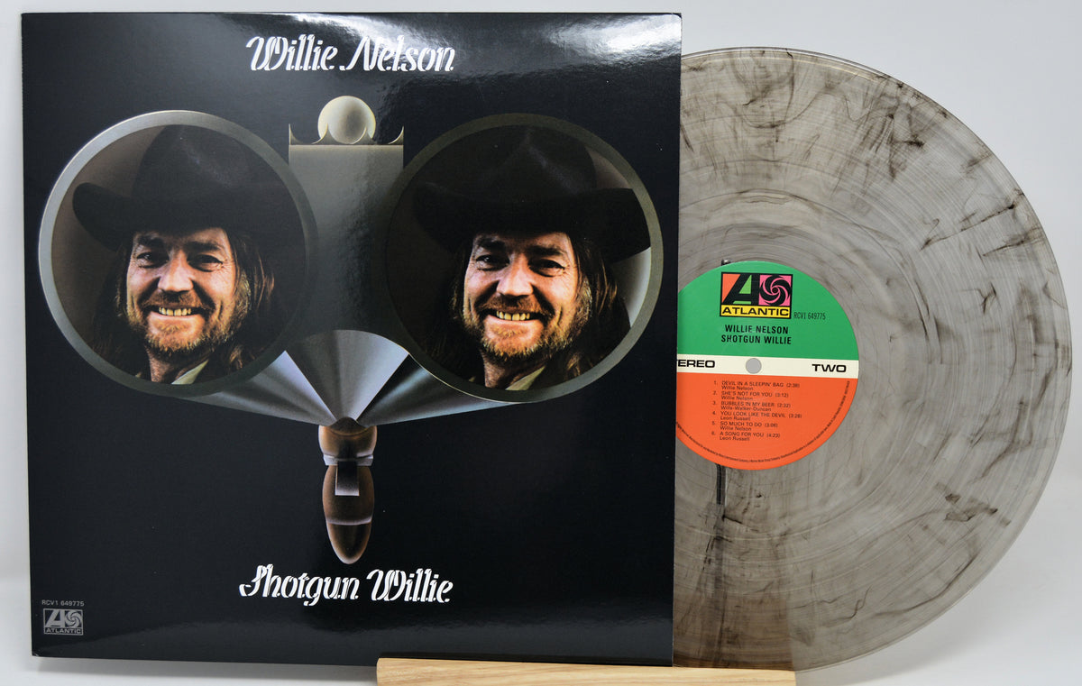  Willie Nelson 'Shotgun Willie' vinyl record album with the black cover jacket and a marbled translucent record partially visible behind it on a light gray background.
