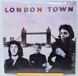 A vinyl record sleeve for the band London Town, featuring a black-and-white photo of the three band members in front of Tower Bridge in London. The band name 'LONDON TOWN' is printed across the top in multicolored letters.