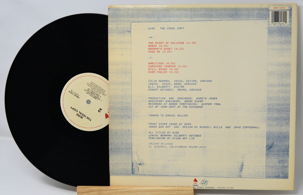 Vinyl record with cover displaying track listings on a light gray background
