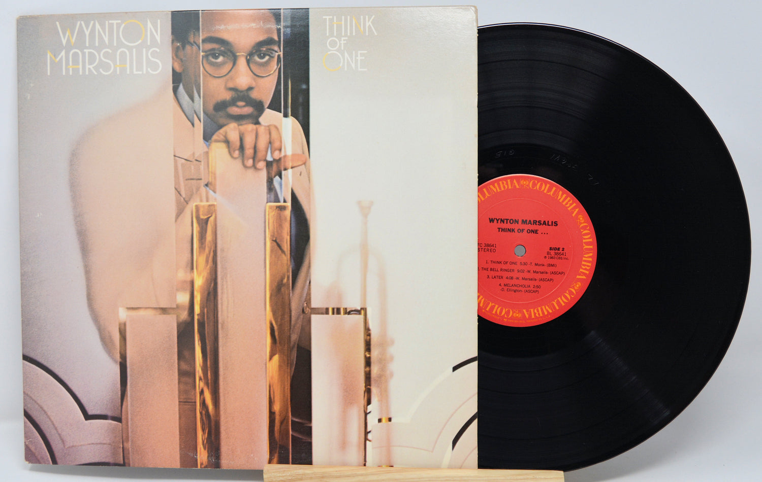 Vinyl record with cover featuring a person, on a light gray background
