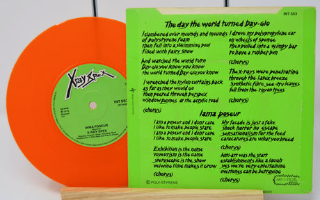 Vinyl record with orange cover and green label featuring text and logo.