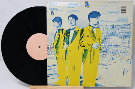 Vinyl record with a cover featuring three people in yellow suits on a white background