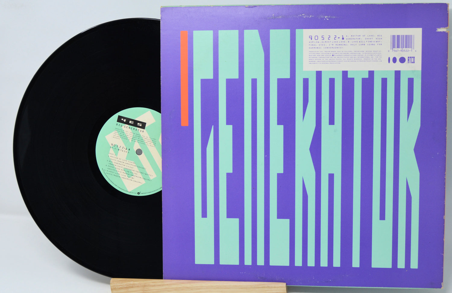 Vinyl record with cover displaying a colorful album design on a white background