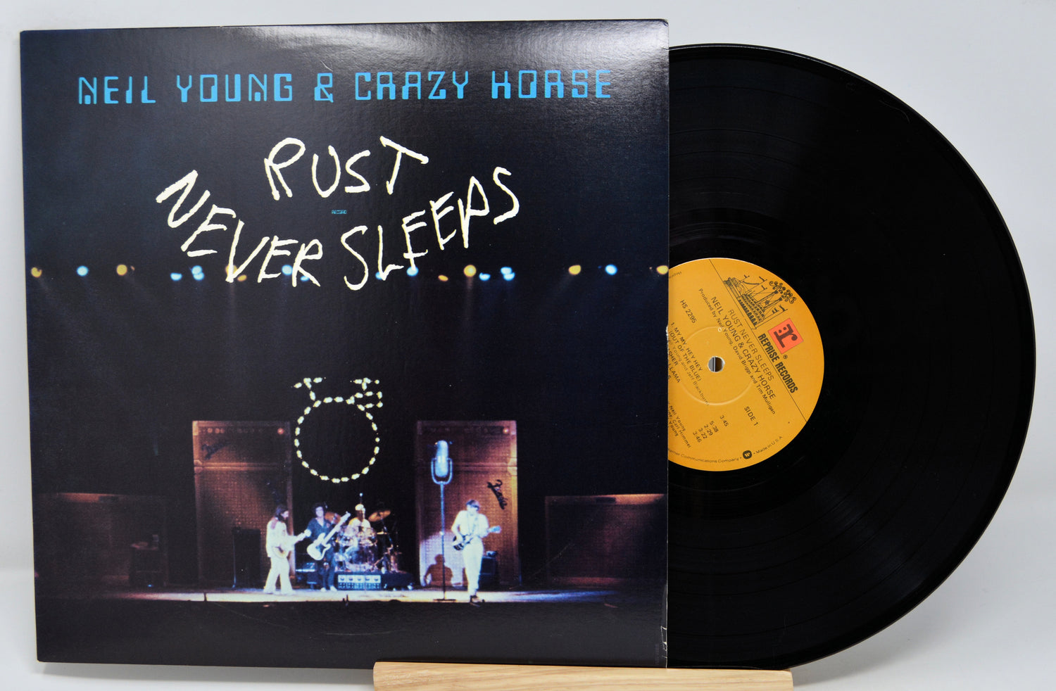 Vinyl record by Neil Young and Crazy Horse titled Rust Never Sleeps showing the album and front cover with a picture of the band on stage