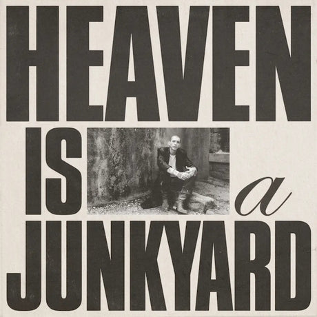 Black and white album cover for Youth Lagoon with the text 'HEAVEN IS A JUNKYARD' and a photograph of a person sitting against a textured background.