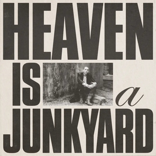 Black and white album cover for Youth Lagoon with the text 'HEAVEN IS A JUNKYARD' and a photograph of a person sitting against a textured background.