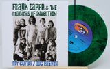 A green splatter vinyl record titled 'Frank Zappa & The Mothers of Invention - My Guitar / Dog Breath'. The cover shows a group photo of the band members.