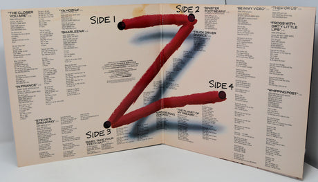 Album cover with a stylized letter 'Z' made of red sticks on a beige background with text.