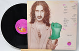 Vinyl record with a person holding a green object on the cover