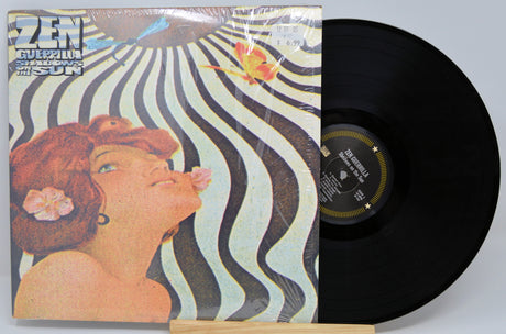 Vinyl record and cover for the album 'Zen Guerilla - Shadows On The Sun' with a striped background and a woman's face in the center.