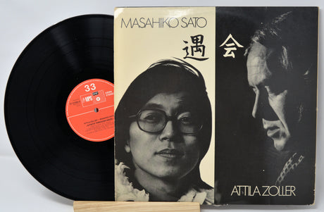 Vinyl record with cover featuring a portraits of the artisits and text, on a white background