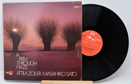 Vinyl record with cover featuring trees and 'A Path Through Haze' by Attila Zoller and Masahiko Sato text