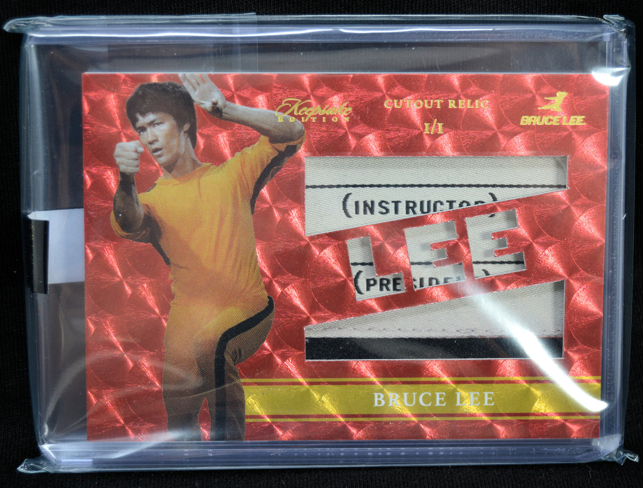 Collectible card of Bruce Lee in a yellow outfit with red background