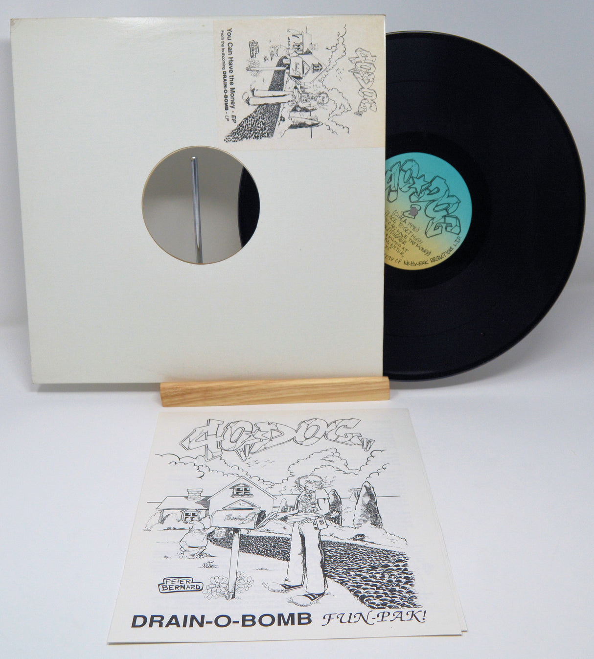 A vinyl record and its sleeve with a cartoonish illustration and text. The record is labeled '40 Dog - You Can Have The Money'.