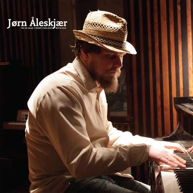 A person seated at a piano playing a musical instrument, with his studio album 'I'm So Glad I Spent This Day With You' featured.