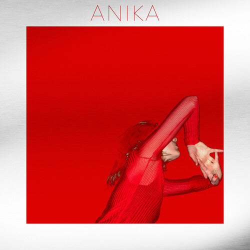 Red vinyl record cover with the artist name 'Anika' at the top and a silhouette of a person with their hands raised and fingers spread below.