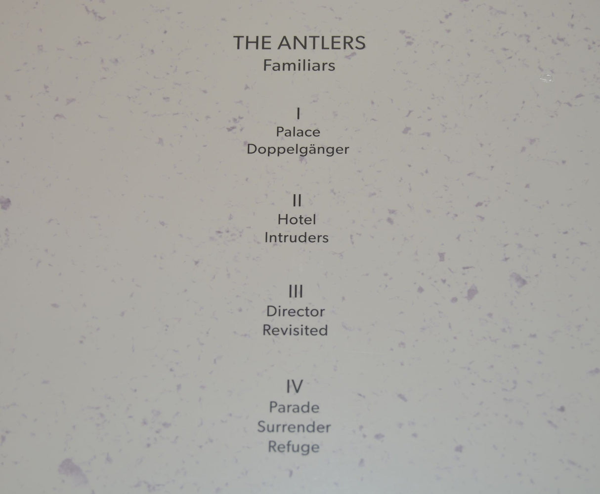 A purple vinyl record of Antlers - Familiars with a sculptural representation of two human figures in a similar purple hue.