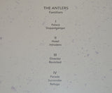 A purple vinyl record of Antlers - Familiars with a sculptural representation of two human figures in a similar purple hue.