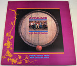 Vinyl record cover for Applejack featuring an image of a group of people playing musical instruments in front of a barrel, with the title 'Contra Dance Music New England Style' and the band name 'Applejack'.
