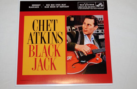 A 7-inch record of Chet Atkins titled 'Midnight' with a red and yellow cover featuring a black and white photo of Chet Atkins playing a guitar.