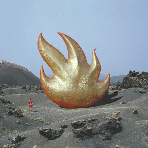 A vinyl record album cover for the band Audioslave featuring a large, flame-shaped sculpture in a desert landscape with a person standing in front for scale.