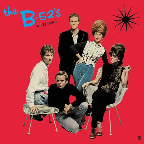 The cover art for 'The B-52's - Wild Planet' vinyl record featuring the band members seated and standing against a red background, with a stylized star motif above them.