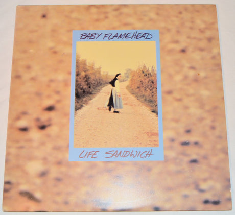 Used vinyl record titled 'Baby Flamehead - Life Sandwich' with a picture of a person walking down a road on the cover.