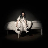 Billie Eilish 'When We All Fall Asleep' album cover with a person sitting on a bed in a dimly lit room, wearing a white outfit.